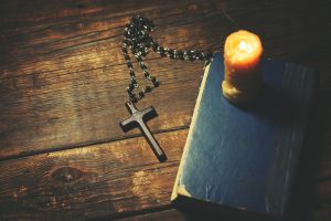 cross, book and candle on wooden background